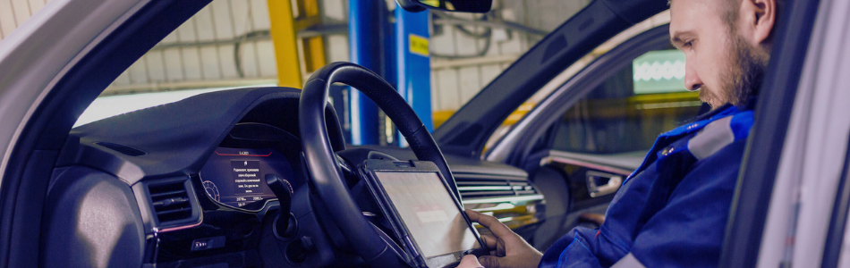 Man in a car looking a tablet screen