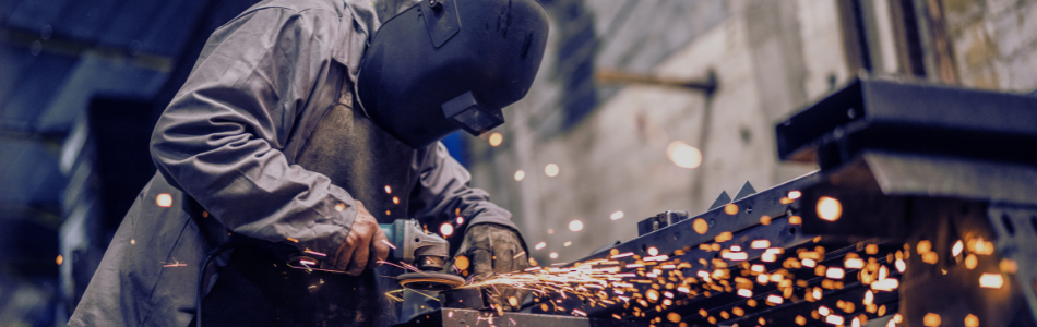 Welder wearing mask working with steel
