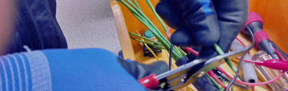 hands with gloves on inspecting electrical wiring